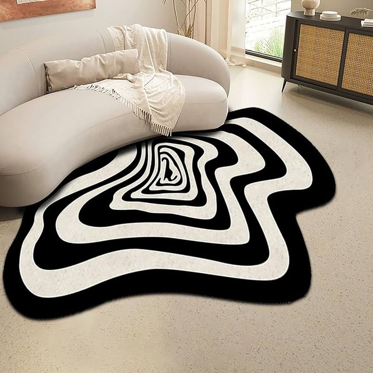 a black and white area rug in the middle of a living room with a couch