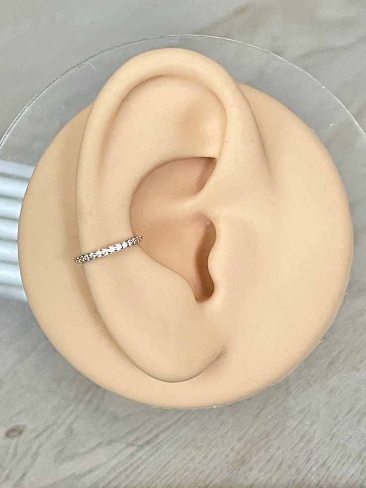 a close up of a fake ear with a ring in it's middle on a table