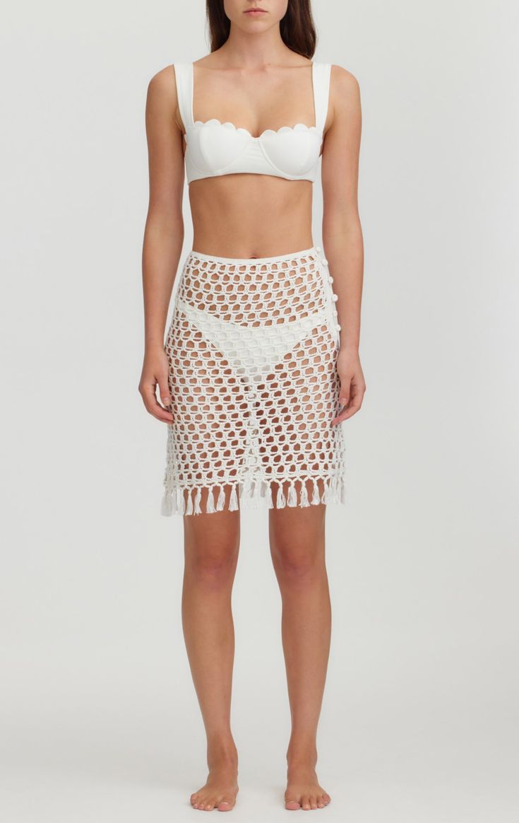 Crafted from 100% cotton, this delicate mini skirt is a timeless piece for your wardrobe. Its mini-length silhouette and refined fringe along the hem makes it a stylish statement, with intricate hand crochet detail that gives it a luxe feel. Wear over any of our Maillots for added bottom coverage and elevate your look. Crochet Trim Mini Skirt For Beach, Crochet Mini Skirt For Beach In Summer, Mini Skirt Set Crochet Pattern, Beach Crochet Mini Skirt, Beach-ready Asymmetrical Mini Skirt, Monet Earrings, Victoria Secret Angels, Crochet Details, Hand Crochet