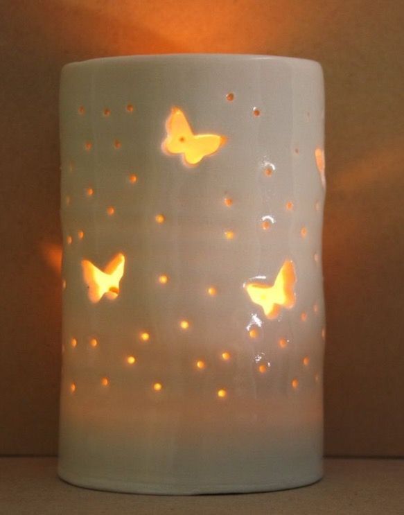 a lit candle that has some butterflies on it