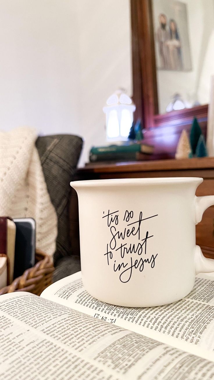 a coffee cup sitting on top of an open book