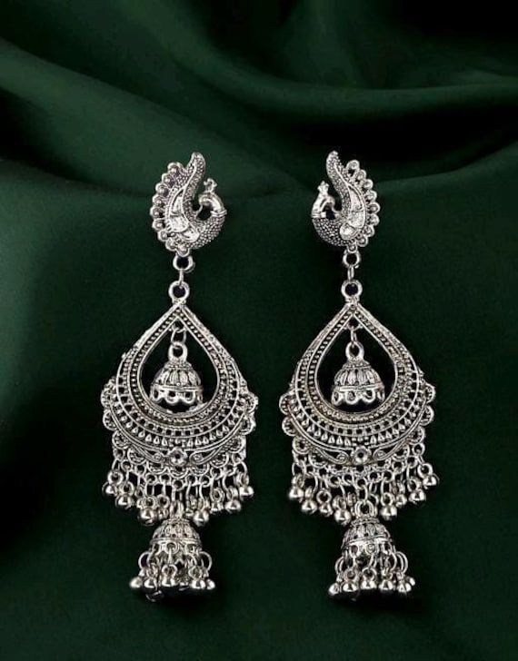 Base Metal-Alloy, Silver Platting Stone-Artificial Stone and Beads Sizing- Non adjustable Stylish Silver Oxidized Indian drop Earrings- An Eternal Classical Design. These Vintage earrings will complement any Occasion Ethnic Wear/ Daily / College / Party Wear. Produced under Quality Control; One by One Checking; Focus on Detail Processing. Top Quality/ Latest Trend Design/Anti-Allergy Beautiful Looks at One Glance- with Intricate High Polish creates Glamorous Reflections and adds Luxurious Looks. Traditional Style Danglers With Tilla For Eid, Traditional Danglers With Tilla For Eid, Traditional Danglers For Eid, Bohemian Chandbali Earrings For Eid, Traditional Latkan Jewelry For Eid, Traditional Latkans Jewelry For Eid, Bohemian Festive Jhumkas, Bohemian Jhumkas Drop Earrings For Diwali, Bohemian Drop Jhumkas For Festivals