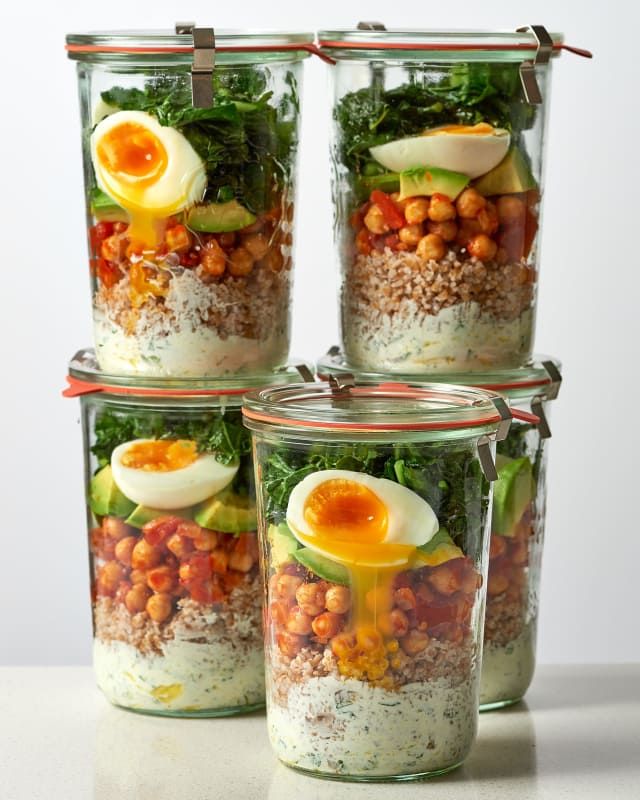 four glass containers filled with food on top of a table