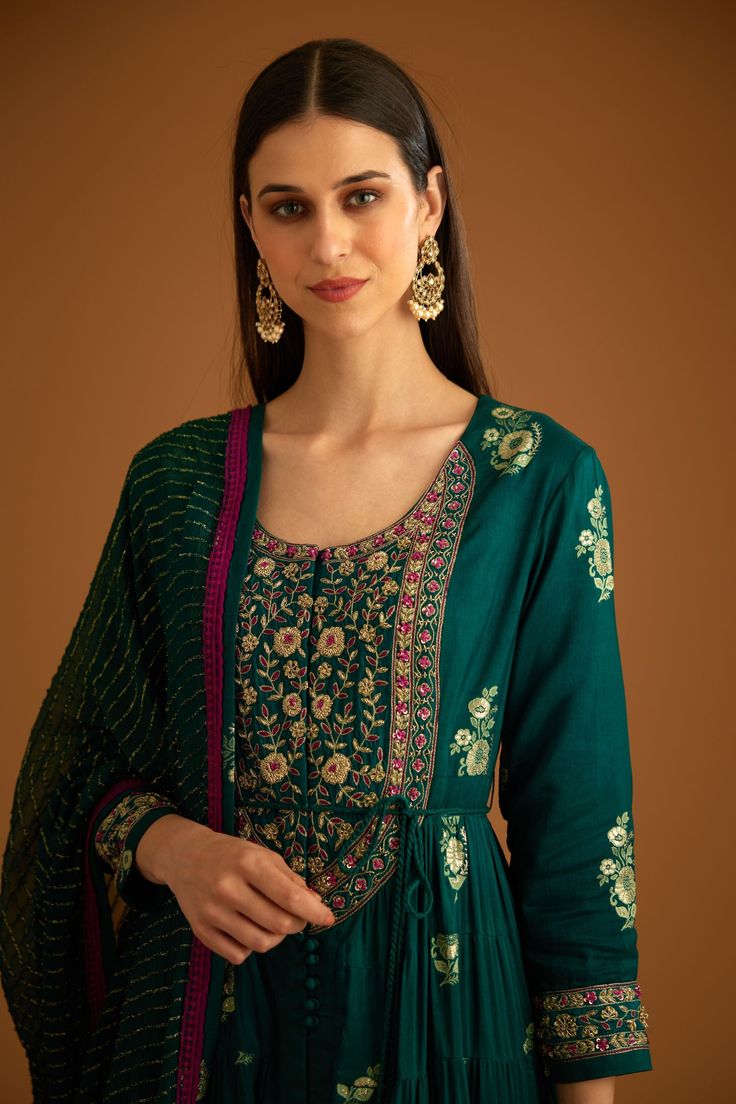 Editor's Note Featuring a zardozi embroidered brocade anarkali with flat chiffon dupatta and trousers Color: Bottle green Fabric: Viscose brocade, cotton satin, flat chiffon Embroidery details: Applique, gota and thread embroidery Anarkali length: 57", trouser length: 38" Components: Anarkali, trouser & dupatta Occasion: Festive Care: Dry clean only About the Designer Shyam Narayan Prasad started his journey in the Indian Fashion Design Industry with a couture women’s wear collection. The design Transitional Anarkali Set In Jamawar, Anarkali Set With Intricate Embroidery And Straight Kurta, Festive Anarkali Palazzo Set With Zari Work, Embroidered Floor-length Green Palazzo Set, Festive Anarkali Set With Intricate Embroidery, Intricate Embroidered Anarkali Set For Festivals, Anarkali Silk Sharara For Designer Wear, Anarkali Art Silk Palazzo Set With Zari Work, Diwali Jamawar Anarkali Set