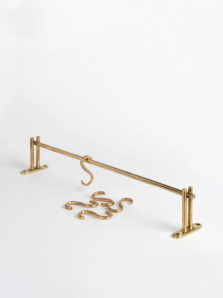 a pair of brass hooks on a white background