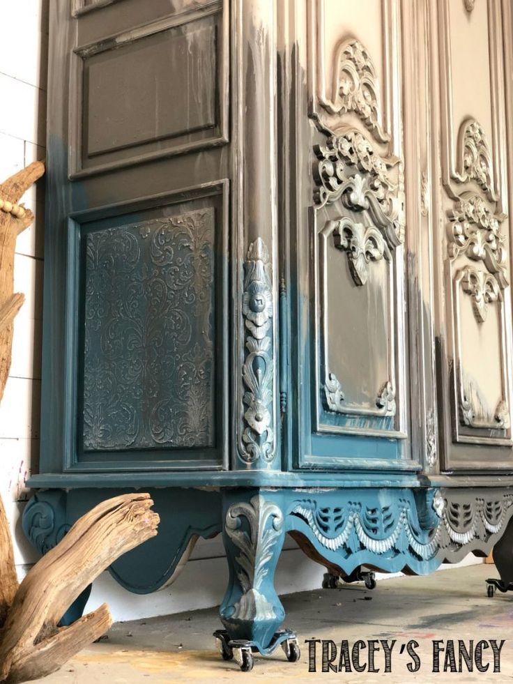 an old dresser is painted blue and has ornate carvings on it