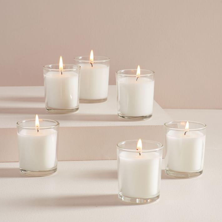 six white candles sitting on top of each other