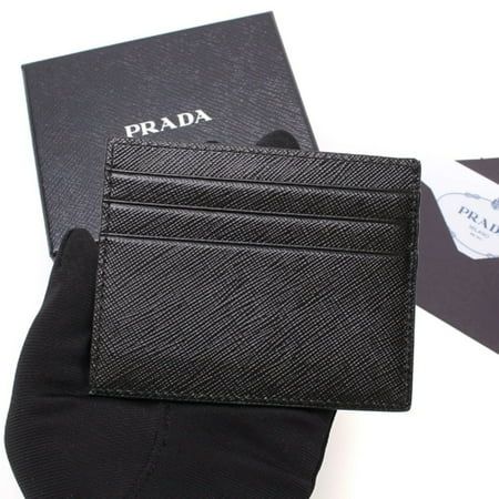 This stylish Prada Card Holder is the perfect addition to your everyday essentials. The iconic Prada Embossed logo is featured prominently on the front. With six slots for cards as well as one down the middle, there is plenty of storage for all of your needs. Its small size and neutral color makes this leather card holder perfect to place in your pocket or bag. Made in Italy. Model: 2MC223 Black and Grey Saffiano Leather Prada Silver Logo Six card holder slots One bill compartment Measurements: Elegant Leather Card Holder With Logo, Designer Business Card Holder With Logo, Designer Logo Card Holder For Business, Elegant Rectangular Logo Card Holder, Classic Business Card Holder With Logo, Classic Business Wallet With Logo, Designer Rectangular Card Holder With Logo, Black Rectangular Card Holder With Logo Plaque, Classic Leather Card Holder With Embossed Logo