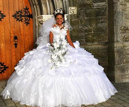 a woman in a wedding dress sitting on a chair