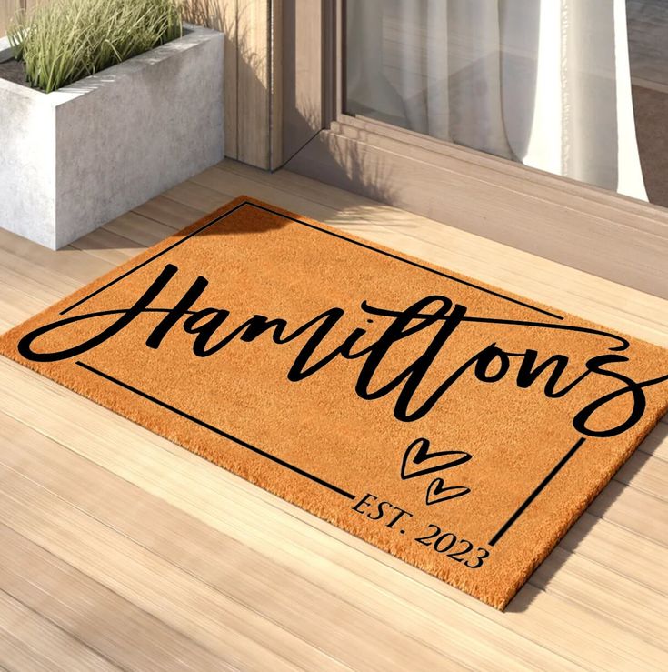 a welcome mat with the name harry on it in front of a door and potted plant