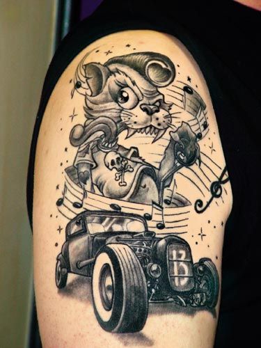 a man with a tattoo on his arm that has an image of a cat driving a car