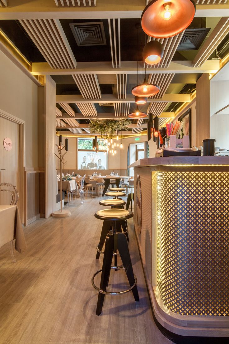 an empty restaurant with bar stools and lights