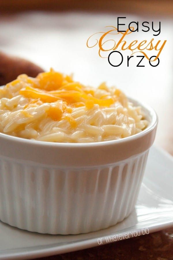 a white bowl filled with macaroni and cheese sitting on top of a plate