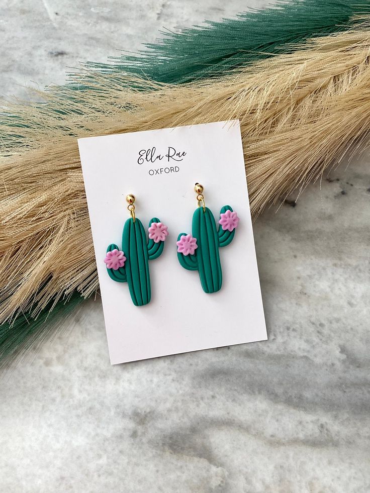 the cactus earrings are green with pink flowers