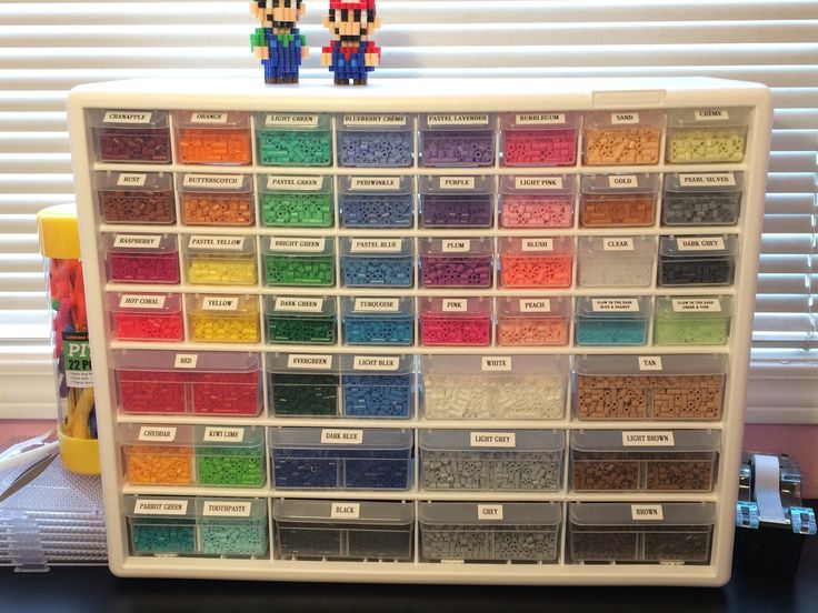 a plastic storage box filled with lots of different colored beads on top of a table