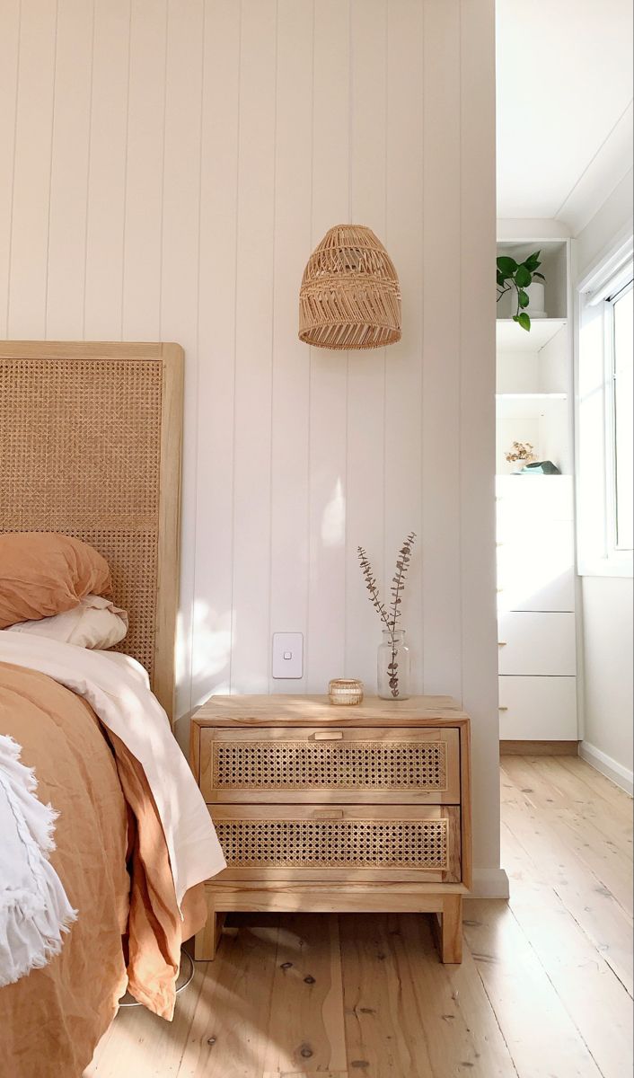 a bedroom with a wicker headboard and white walls