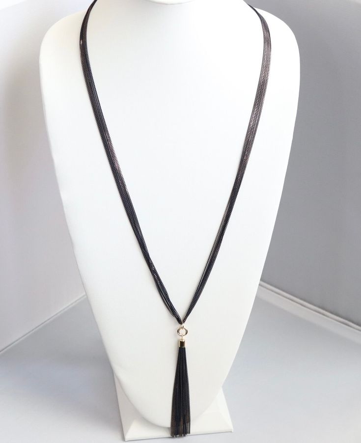 This necklace is the perfect accessory for any occasion. It's made of black rope and has a black tassel. The black color is perfect for any outfit, and the tassel adds a bit of personality. Elegant Lariat Jewelry As Fashion Accessory, Elegant Metal Tassel Necklace, Elegant Metal Tassel Necklace For Parties, Elegant Black Choker Jewelry, Elegant Lariat Necklace, Elegant Layered Pendant Necklace For Parties, Formal Long Necklace With Clavicle Chain, Elegant 16 Inch Snake Chain Jewelry, Evening Black Beads Choker Necklace