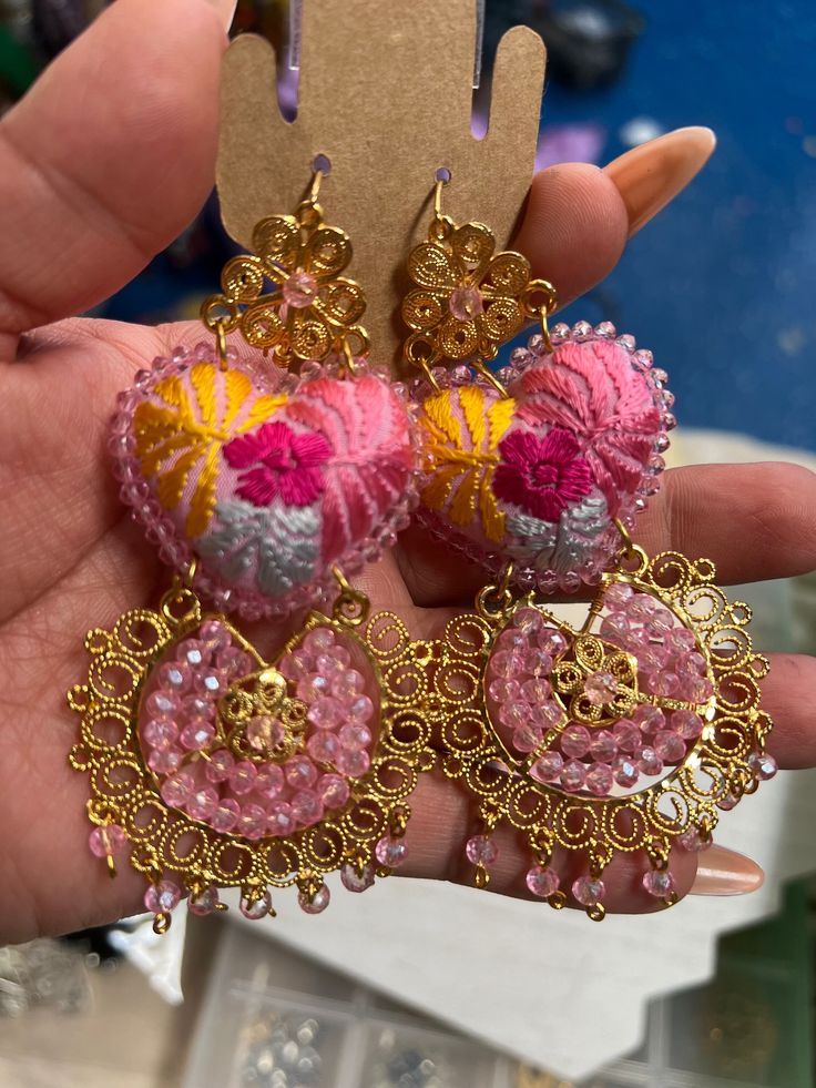 Beautiful and unique handmade earrings hand embroidered by Mexican artisans. We complement with pieces of handmade filigree 18k gold plated. Filigree is a handcrafted jewel made using the olfebre technique with silver, copper, and tumbaga threads and then plated in 18k gold. Pink Embroidered Jewelry For Festive Occasions, Bohemian Embroidered Earrings For Festive Occasions, Festive Pink Embroidered Jewelry, Pink Embroidered Wedding Jewelry, Bohemian Floral Embroidered Earrings As Gift, Bohemian Floral Embroidery Earrings For Gifts, Bohemian Embroidered Festive Earrings, Traditional Pink Embroidered Jewelry, Mexican Filigree Heart Dangle Earrings