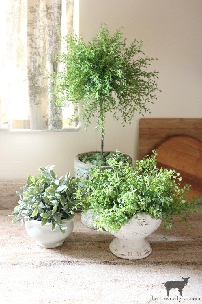 three potted plants sitting on top of a table next to a window sill