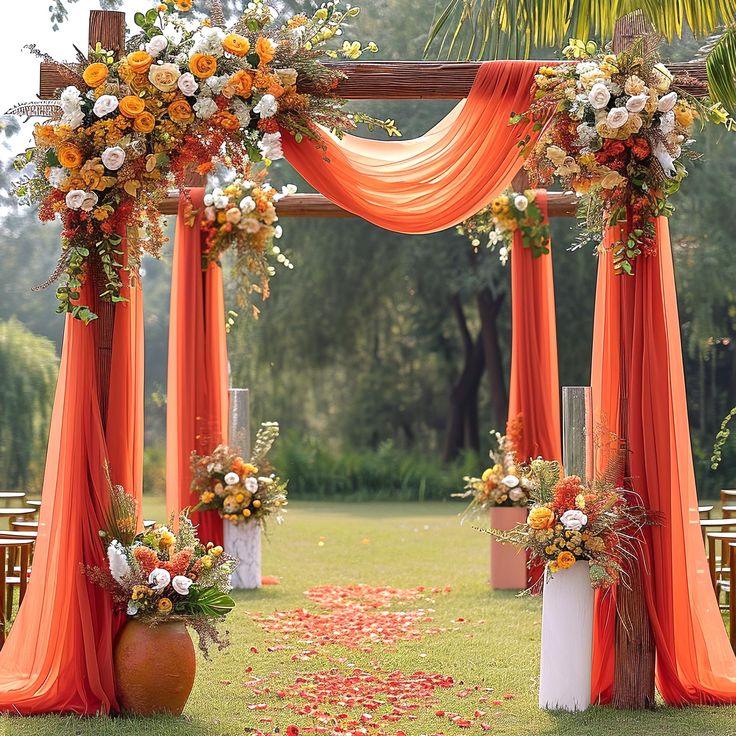 an outdoor ceremony with orange draping and flowers on the aisle, along with white vases