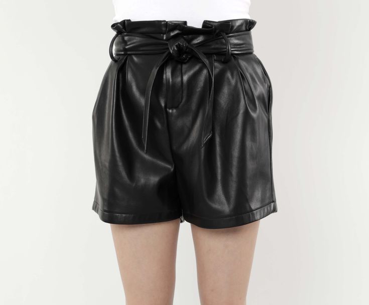 Jazz up your wardrobe with our Faux Leather Paper Bag Shorts. High-waisted and featuring a ruffled waistline cinched with a wide belt, these on-trend shorts add a touch of contemporary style to any ensemble. The paper bag design offers a playful and feminine aesthetic that contrasts with the edgy vibe of the faux leather material, giving you a unique piece that makes a defiantly bold statement. Faux leather Paper Bag waist Belted Available in Black and Camel Dry Clean Polyurethane Final Sale Ite Belted Black Shorts, Black Belted High-waisted Shorts, Black High-waisted Belted Shorts, Workwear Shorts With Belt Loops And Paperbag Waist, Chic High-waisted Shorts With Belt, High Waist Belted Shorts For Spring, Chic Short Bottoms With Belt, Belted Shorts For Summer Night Out, Chic Black Belted Shorts