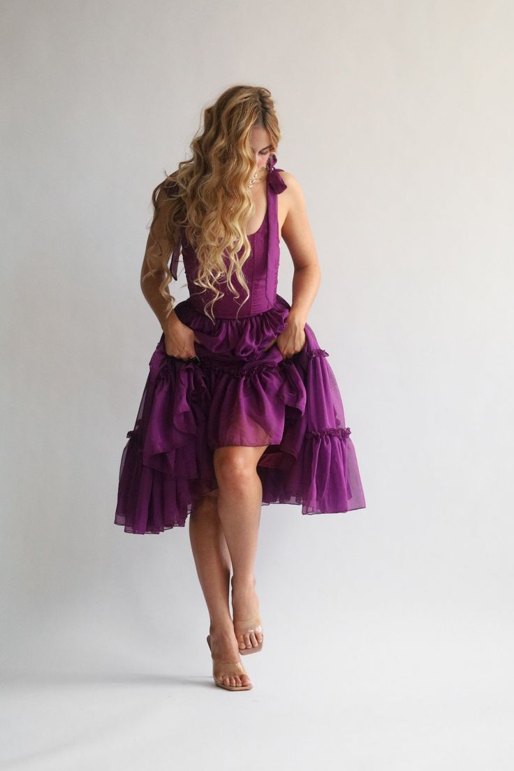 Orders ship out approx 1-3 days after purchase. Transit times approx 3-5 days for US destinations. Our signature Siena is THE main character dress. Siena features a three tier dress in the perfect shade of dark jewel-tone purple.The bust features V shaped corset boning that gives a flattering look. The Siena features a functional corset back closure that you can tighten for a snatched bodice look, adjusting the bust and the waist, helping you get the perfect fit every time. The scooped neckline Purple Knee-length Prom Dress, Sleeveless Purple Corset Dress For Costume Party, Purple Ruffled Mini Dress For Prom, Purple Fairy Dress With Ruffles For Weddings, Purple Sleeveless Fairy Dress For Party, Purple Ruffled Prom Dresses, Sleeveless Purple Fairy Dress With Ruffles, Purple Sleeveless Fairy Dress With Ruffles, Purple Corset Dress With Ruffles