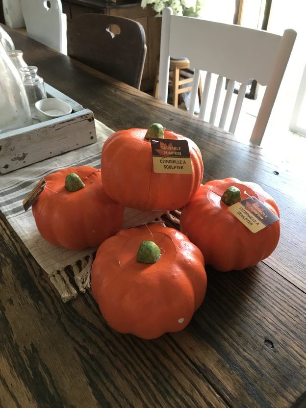 four pumpkins sitting on top of a wooden table