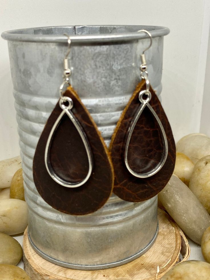 "Handmade, genuine leather charm teardrop earrings measuring Aprox 2\" long in a variety of colors and metal color options either tools or silver. Available options are: Weathered brown leather teardrop earrings with coordinating charm in silver or gold Camel, cognac teardrop earrings with coordinating charm in silver or gold Hunter green, Forrest green teardrop earrings with coordinating charm in silver or gold Teardrop earrings, gold earrings, silver earrings, fall earrings, camel earrings, co Everyday Hand Tooled Leather Jewelry, Everyday Hand-tooled Leather Jewelry, Faux Leather Drop Earrings, Leather Dangle Earrings With Ear Wire, Everyday Hypoallergenic Brown Jewelry, Handmade Teardrop Faux Leather Earrings, Adjustable Brown Teardrop Jewelry, Leather Dangle Jewelry For Everyday, Everyday Leather Dangle Jewelry