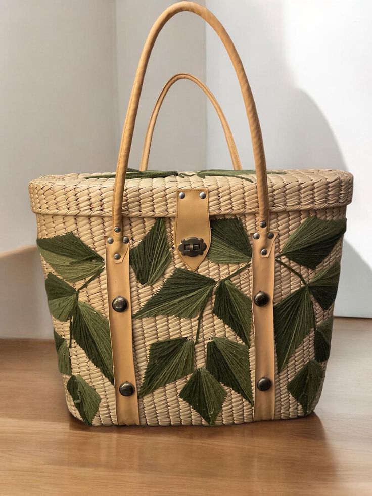 This amazing vintage 60's market raffia bag has stood the test of time! It was well kept and is excellent vintage condition.  Brighten moms day with a gift of the past. Perfect for shopping at the farmers market or going to the beach. It would look wonderful displayed at home in a sunroom or throw a blanket in it and sit it next to the couch. Absolutely lovely! ❤️ Raffia with embroidered green yarn leaves on front, top and sides. Hinged lid with twist lock. Appropriate measurements: 14.5" x 12.5" x 5.5" Yarn Leaves, Moms Day, Green Yarn, Market Basket, Market Bags, Basket Tote, Market Baskets, Raffia Bag, Mom Day