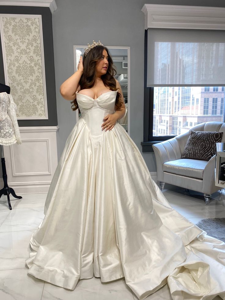 a woman in a white wedding dress is posing for the camera