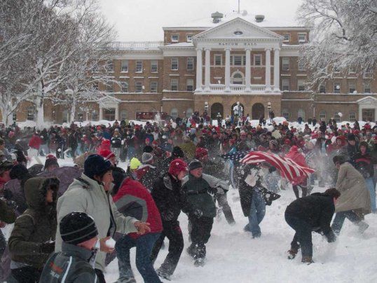 a group of people playing in the snow with an american flag on top of it