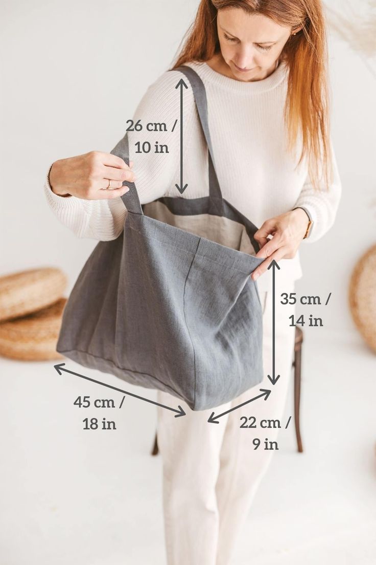 a woman holding a gray bag with measurements