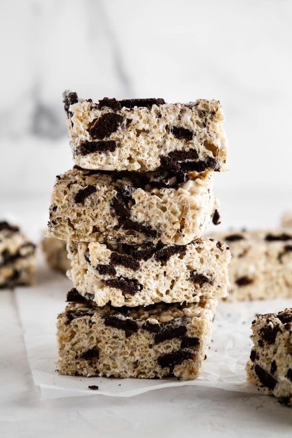 several cookies and bars stacked on top of each other in front of white marble background