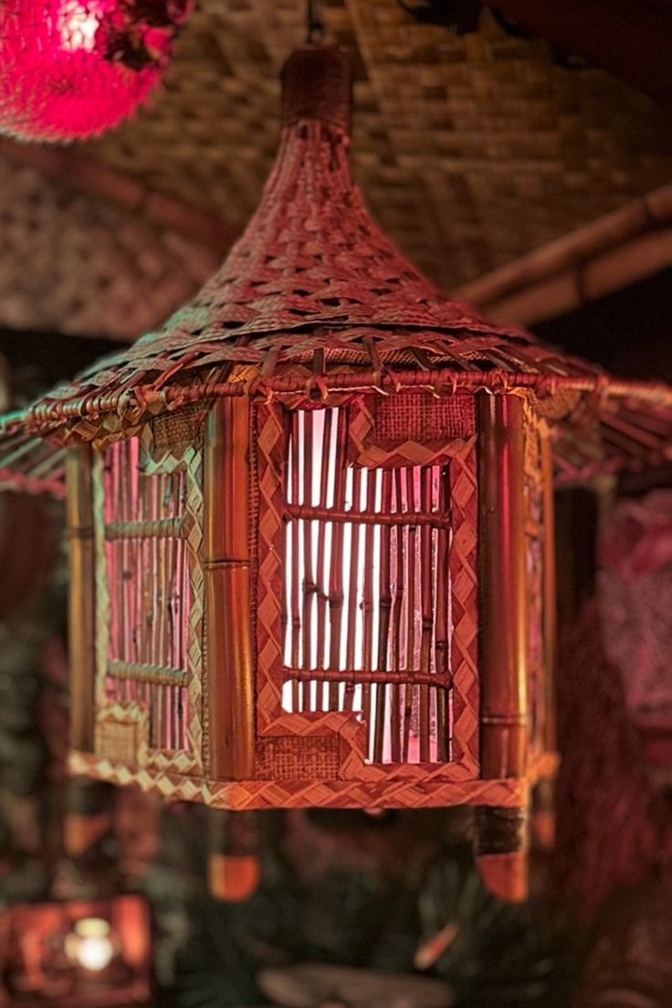 a bird cage hanging from the ceiling in a room filled with candles and other decorations