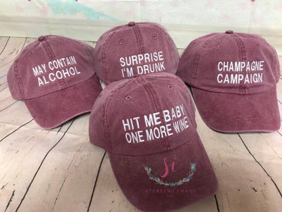 four maroon hats with white writing on them