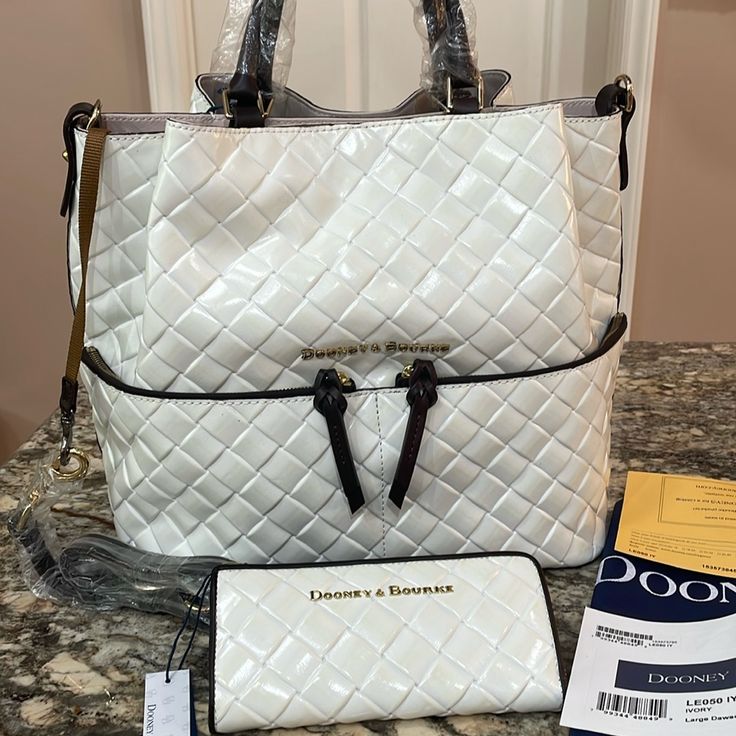 Nwt Dooney&Bourke Lg Dawson Leather Satchel With Matching Leather Wallet Beautiful Ivory Leather With Dark Brown Leather Trim And Goldtone Hardwaretriple Compartment12”H X 14” W X 6”D..Exterior Has 2 Large Zip Compartments . Interior Has1 Lg Zip And Slip Compartments With 2 Smaller Slip Compartmentsmagnetic Closure. Matching Wallet Is 3.5” X 7.5”, Zip Closure. Brand New, Never Used. Dust Bag And Warranty Cards Included. Bag Also Has Leather Shoulder Strap. Smoke Free And Pet Free Home White Leather Everyday Wallet, Everyday White Leather Wallet, Designer White Travel Wallet, Luxury White Wallet For Travel, Luxury White Travel Wallet, White Travel Wallet With Removable Pouch, Luxury White Wallets For Everyday Use, White Leather Wallet, White Leather Travel Wallet