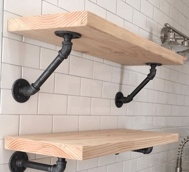 two wooden shelves with pipes on them in a bathroom