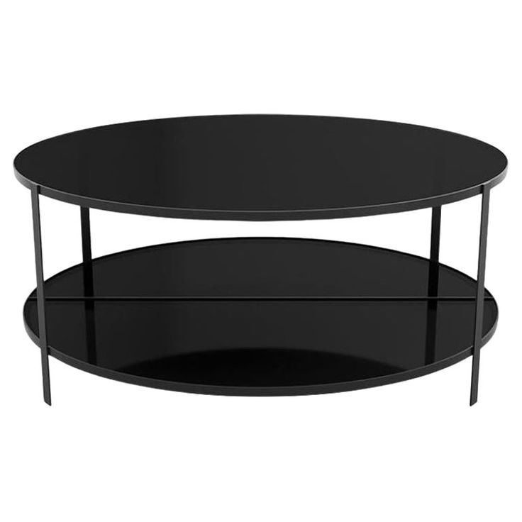 an oval black glass coffee table with two shelves on the bottom and one shelf below it