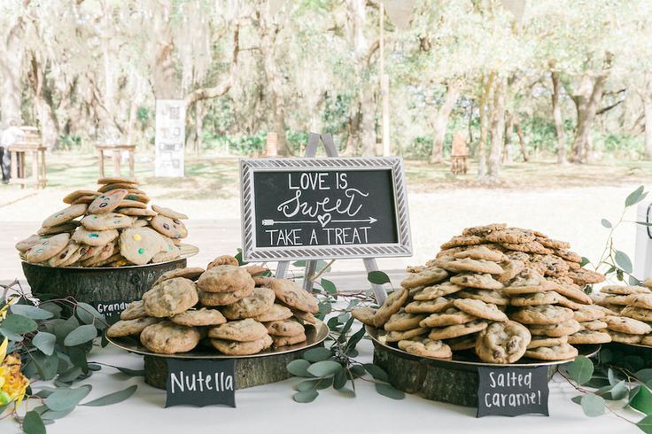 there are many cookies on the table at this outdoor wedding reception, and one is for sale