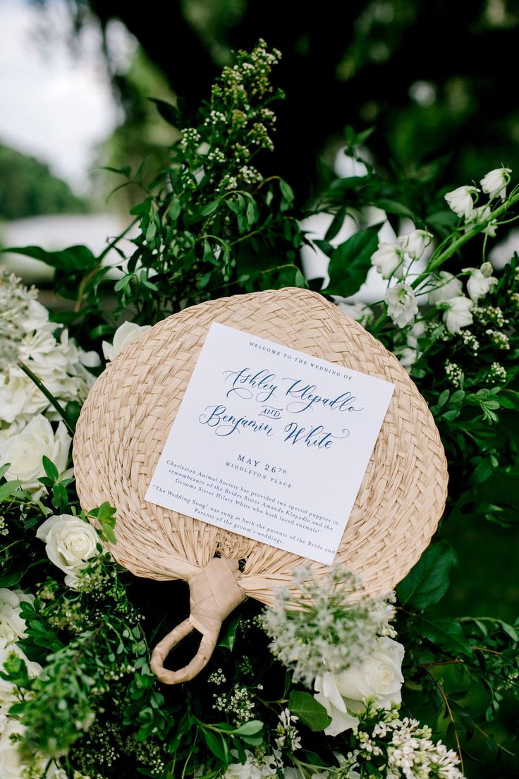 a bouquet with white flowers and greenery on it is shown in front of a sign