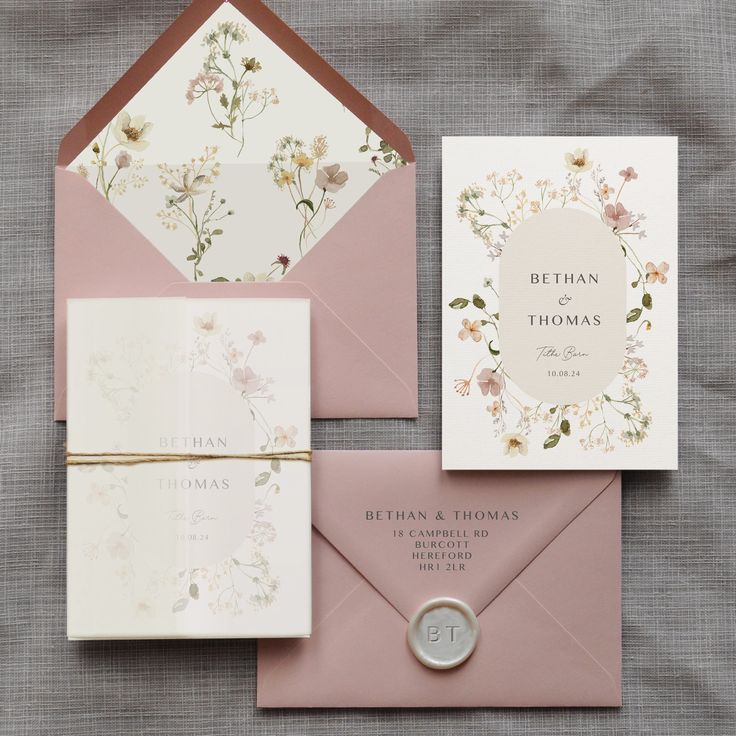 the wedding stationery is laid out on top of each other, including two envelopes