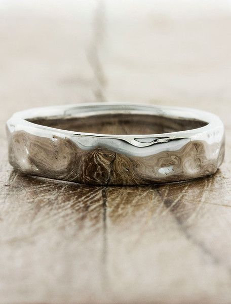 a close up of a wedding ring on a wooden surface