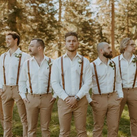 a group of men standing next to each other wearing suspenders and bow ties in front of trees