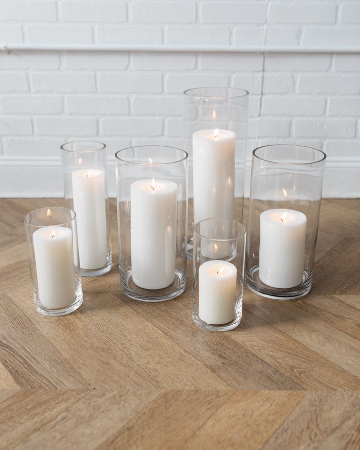 white candles are arranged on a wooden table