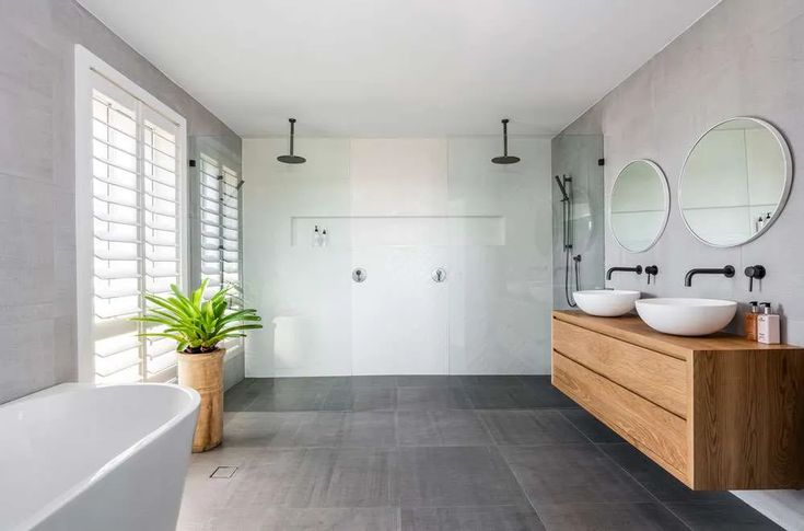 a large bathroom with two sinks and mirrors