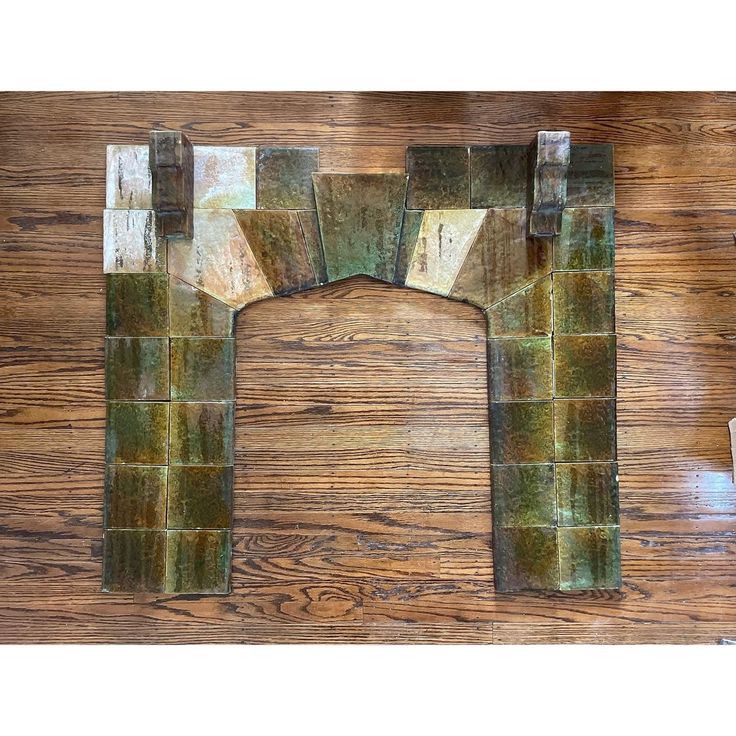 the letter h is made out of green marble blocks on a wooden table with scissors and other items