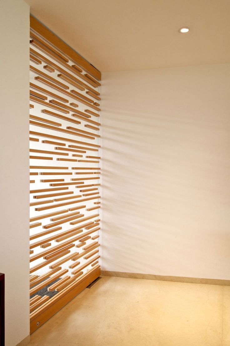 an empty room with wooden slats on the wall