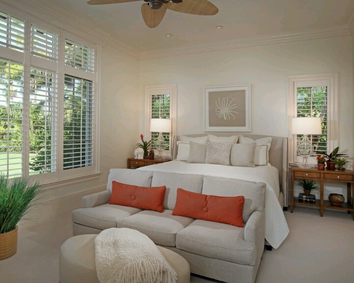 a bedroom with a bed, couch and ceiling fan