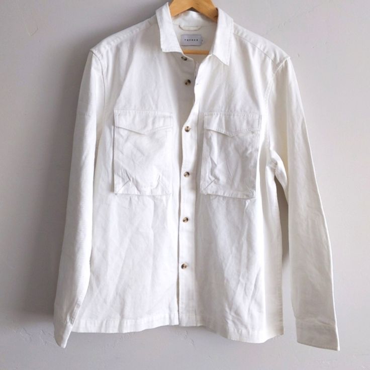 White Jean Button Down Top. Definitely A Trending Piece, New With Tags. Always Accepting Reasonable Offers And Sending Additional Discounts On Bundles! I Am No Longer Taking Measurements, Those Comments Will Be Respectfully Ignored. Happy To Answer All Other Questions! White Lapel Collar Cotton Shirt, White Cotton Shirt With Lapel Collar, Casual White Top With Lapel Collar, White Shirt With Button Cuffs And Lapel Collar, White Button-up Tops With Buttons, White Button-up Top With Pockets, White Shirt With Pockets And Spread Collar, White Shirt With Buttoned Pockets For Work, Spring Shirt With Buttoned Pockets And Spread Collar