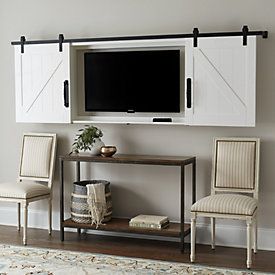 two chairs and a table in front of a flat screen tv mounted on a wall